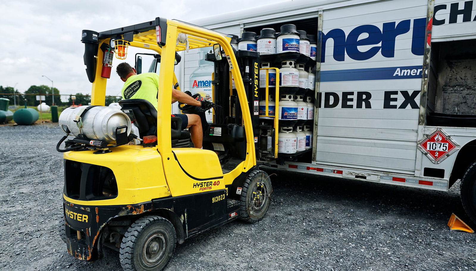 Forklift loading propane into truck.