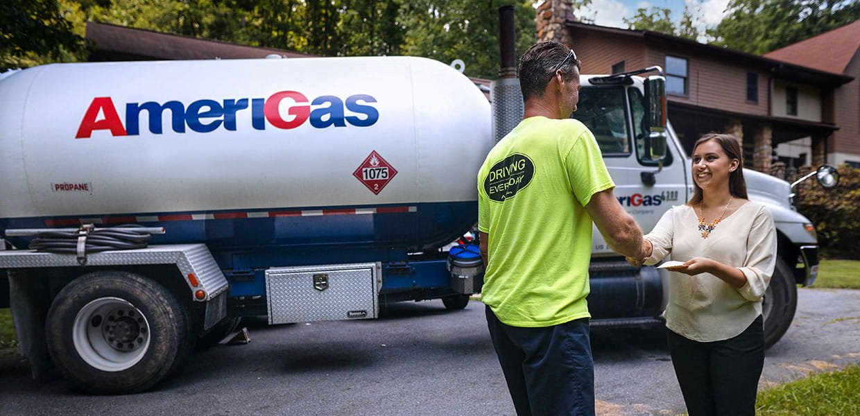 Man and woman shake hands in front of Amerigas truck