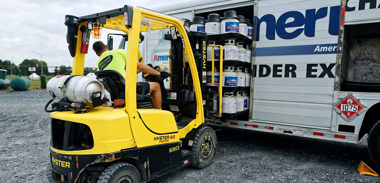 Forklift loading propane into truck.