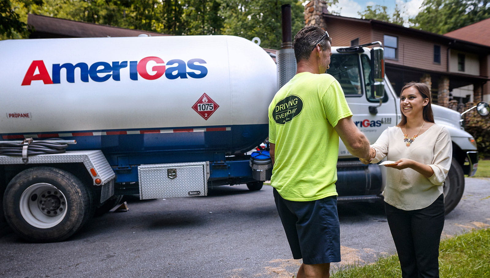 Man and woman shake hands in front of Amerigas truck