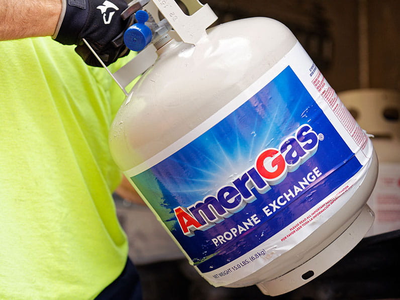 Person holding an AmeriGas propane tank.